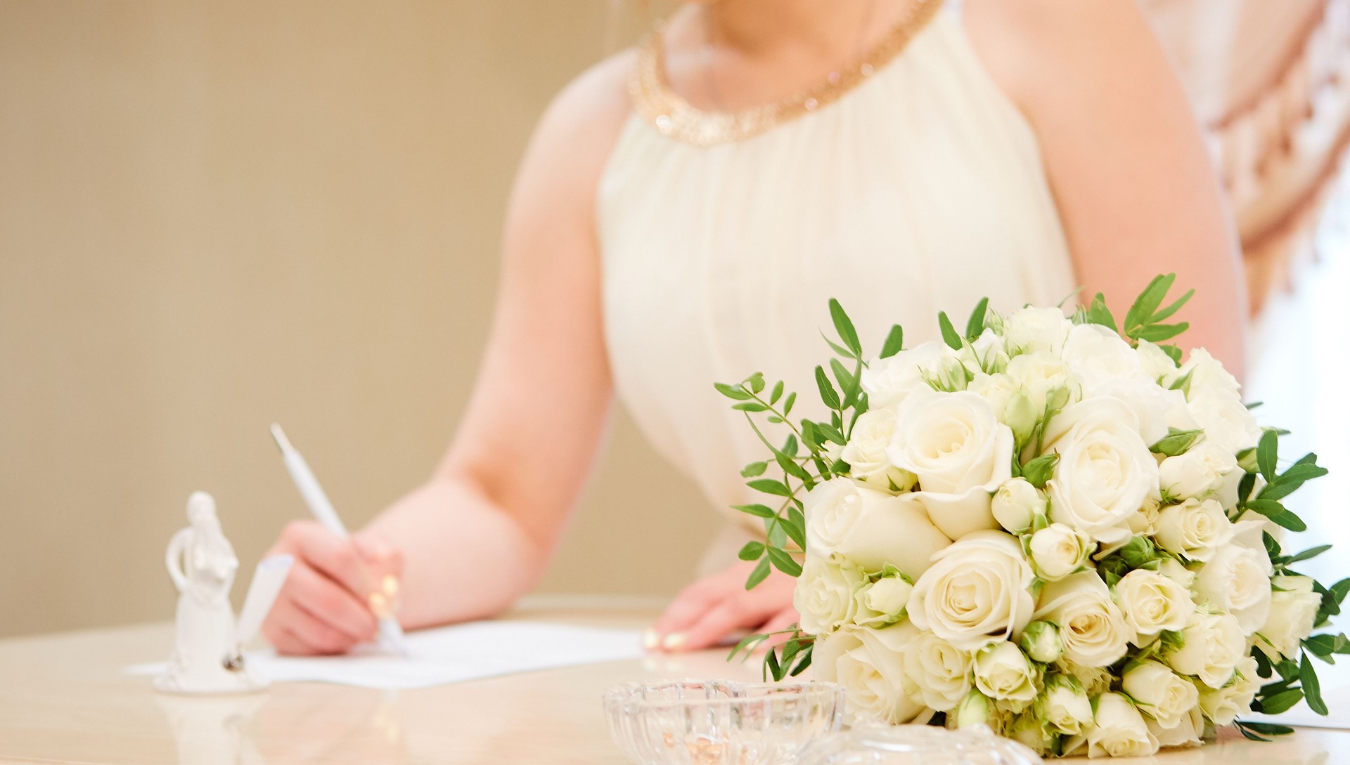 Detail of the hand of a bride who signs the marriage act.